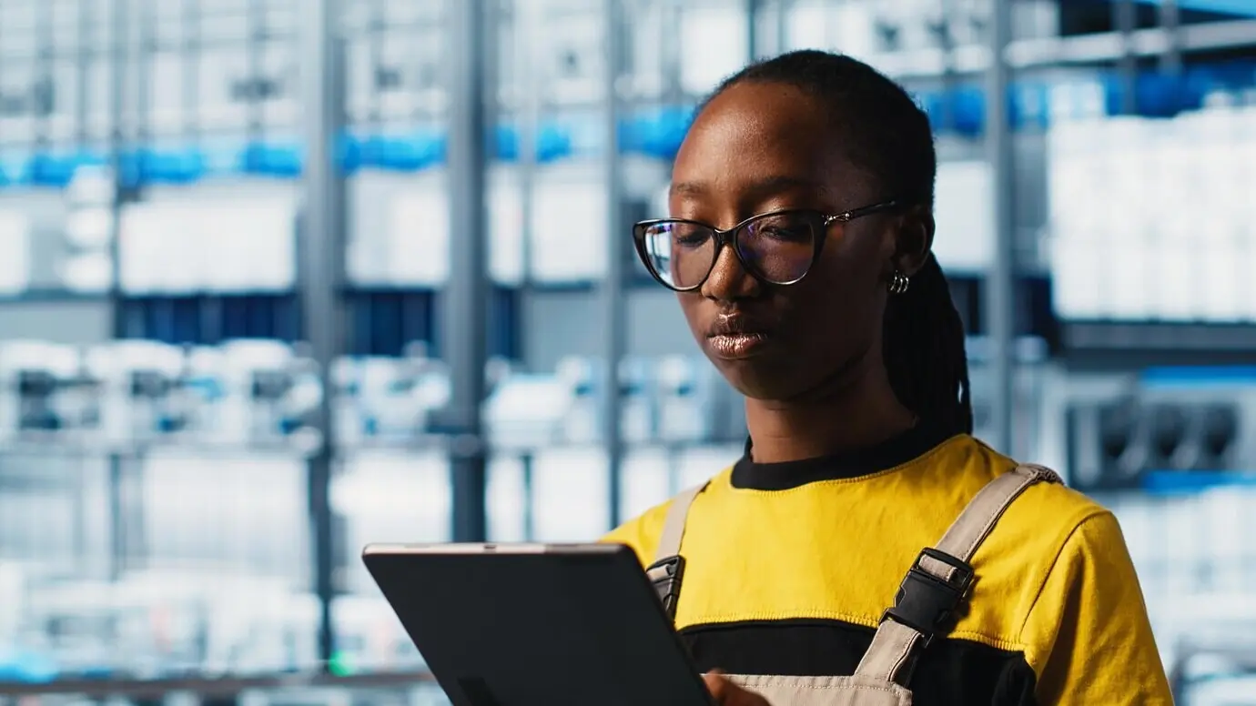 Smart-Factory-Ingenieur setzt automatisierte Arbeitsabläufe mithilfe eines Tablets um.